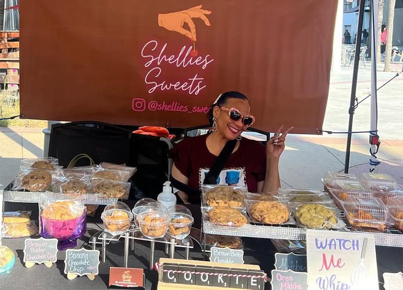 Shellie's Sweets and Vegan Treats founder Michelle Jordan in her booth at a local farmer's market